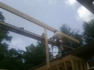 Carpenter setting a ridge beam over a new addition frame — Ice Dam Removal by Roofing Brothers in East Hampton