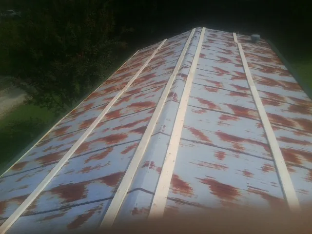 Rusted metal roof panels with new wood purlins before replacement — Storm Damage Roof Repair in East Hampton by Roofing Brothers