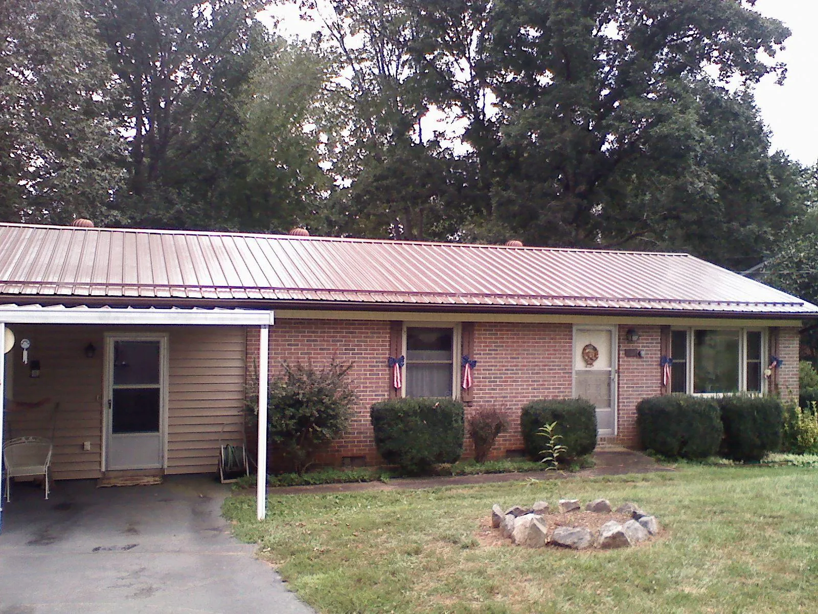 Bronze metal roof and carport on a brick ranch home — Roof Repair work by our crew in East Hampton